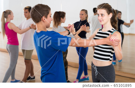 Group of teen dancing salsa in dance studio Group of teen dancing salsa in dance studio 65101895
