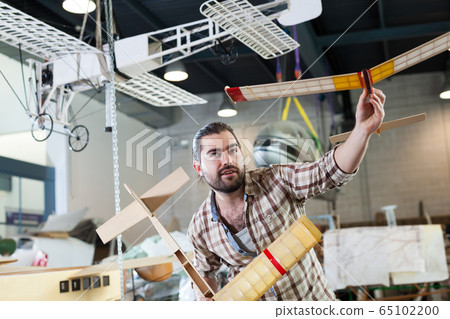 Cheerful male with airplane models Cheerful male with airplane models 65102200