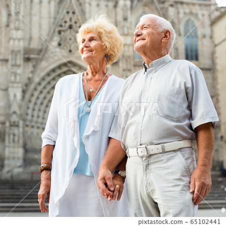 Close up of romantic senior couple on city streets on joint vacation Close up of romantic senior couple on city streets on joint vacation 65102441