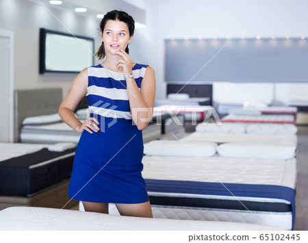 Portrait of customer girl who is shopping in mattress shop. 65102445