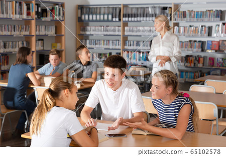 Happy boys and girls brainstorming in teams 65102578