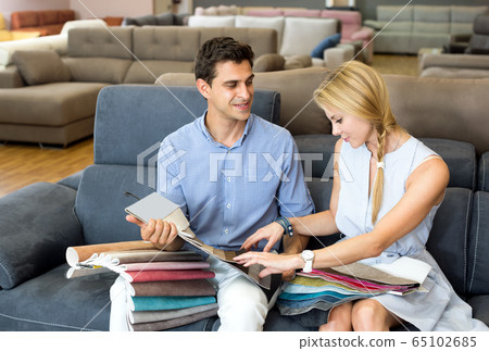 Couple are choosing of colors for new sofa Couple are choosing of colors for new sofa 65102685