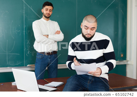 Two guys working on their student project 65102742