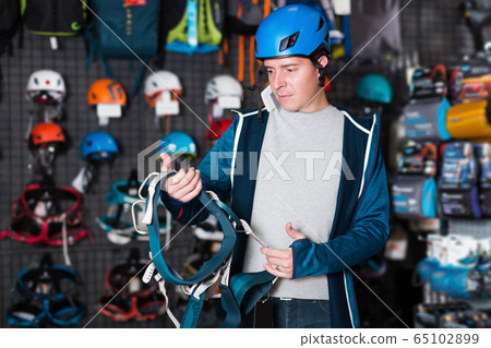 Adult sportsman choosing a sports equipment Adult sportsman choosing a sports equipment 65102899