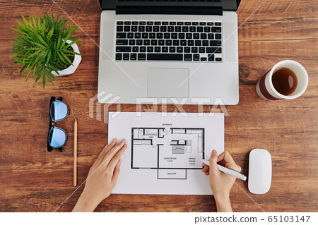 Woman working on apartment blueprint Woman working on apartment blueprint 65103147