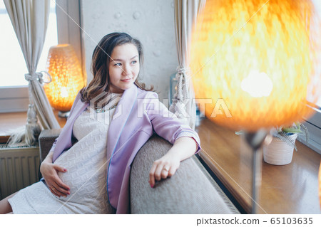 a pregnant woman is stroking her stomach. a girl waiting for a child walks in a shopping center. The concept of a healthy lifestyle , IVF, fashion for pregnant women, children a pregnant woman is stroking her stomach. a girl waiting for a child walks in a shopping center. The concept of a healthy lifestyle , IVF, fashion for pregnant women, children 65103635