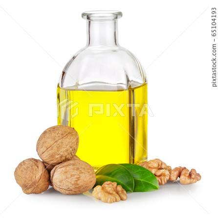 Bottle of walnut oil and walnuts with green leaves 65104193