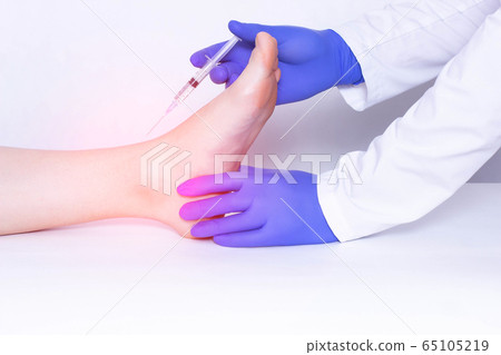 The doctor makes the injection of the patient into the ankle joint, a cotricosteroid and an anti-inflammatory drug with chondroprotector, disease The doctor makes the injection of the patient into the ankle joint, a cotricosteroid and an anti-inflammatory drug with chondroprotector, disease 65105219