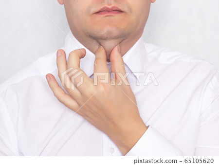 Young caucasian man holds himself up for a fat double chin, concept of charging and exercise against a double chin, close-up, portrait 65105620