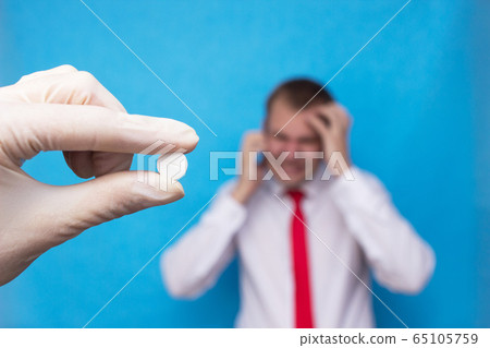 The doctor holds a pill against the background of a man who has side effects on medications, medical, hormonal drugs 65105759