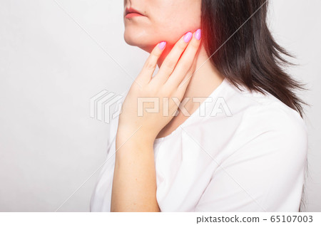 The girl clings to the inflamed salivary gland in which pain. Concept of salivary gland disease, mumps, cancer, copy space 65107003