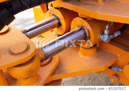 Powerful hydraulic pumps that stand in the bucket of an excavator, industry, close-up, orange Powerful hydraulic pumps that stand in the bucket of an excavator, industry, close-up, orange 65107017
