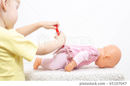 A child plays with a doll and gives her a toy injection. The concept of pediatric medicine, calling a doctor to a child at home, copy space, respiratory infections A child plays with a doll and gives her a toy injection. The concept of pediatric medicine, calling a doctor to a child at home, copy space, respiratory infections 65107047