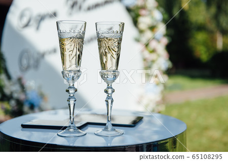 A row of empty champagne glasses on table. Banquet setting A row of empty champagne glasses on table. Banquet setting 65108295