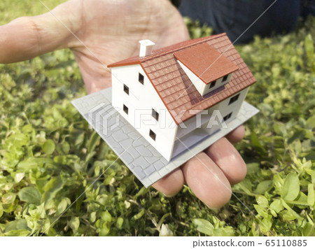 Real estate investment. New house construction concept. Male hands and fingers holding a house scale model 65110885