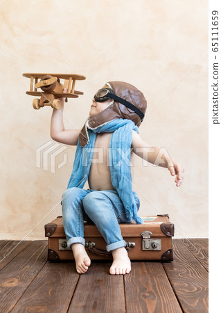 Happy child playing with toy wooden airplane Happy child playing with toy wooden airplane 65111659