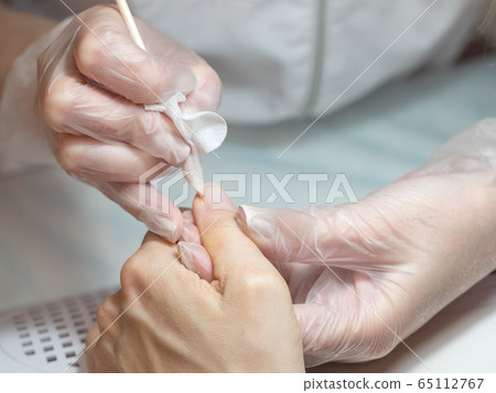 Manicure process. Cleaning the nail from dust 65112767
