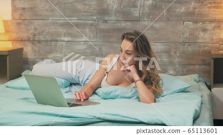Zoom out shot of beautiful woman wearing pajamas 65113601
