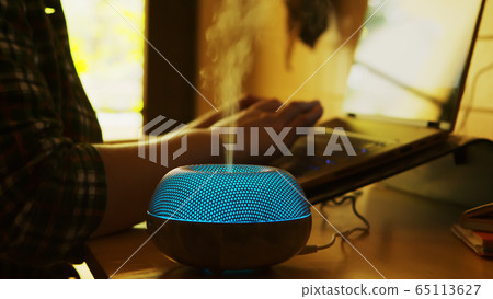 Silhouette of blue led essential oil diffuser steaming Silhouette of blue led essential oil diffuser steaming 65113627