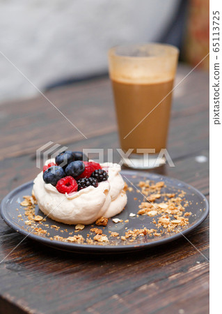 Sweet cakes with summer berries on a wooden table. Sweet cakes with summer berries on a wooden table. 65113725