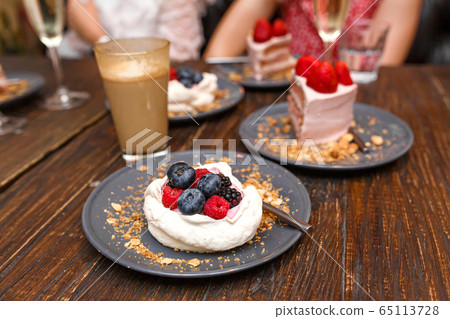 Sweet cakes with summer berries on a wooden table. Sweet cakes with summer berries on a wooden table. 65113728