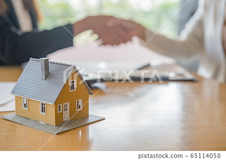 House model with agent and customer discussing for contract to buy, get insurance or loan estate. 65114058