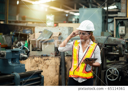 Female industrial engineer wearing a white helmet 65114361