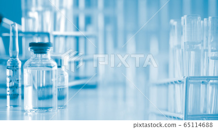 Serum liquid bottle on table with test tube. 65114688