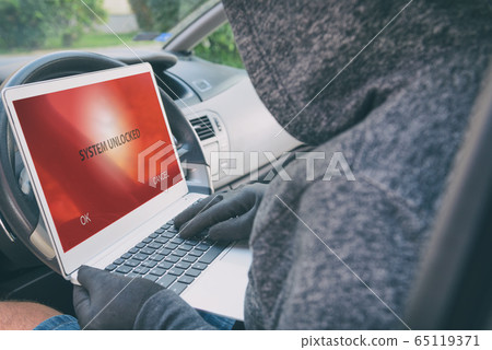 Hooded thief tries to break the car's security 65119371