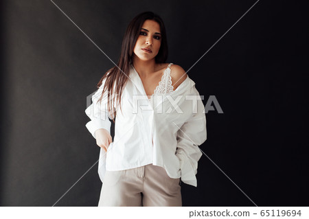 Portrait of a beautiful fashionable oriental brunette woman in a white shirt and shorts 65119694