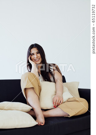 portrait of a beautiful fashionable oriental woman on the couch in home portrait of a beautiful fashionable oriental woman on the couch in home 65119732