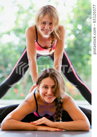 Young active women doing side split stretching Young active women doing side split stretching 65120377