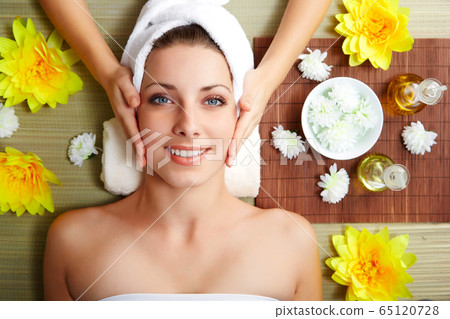 Young beautiful woman in spa environment 65120728