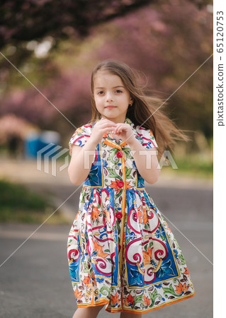 Young girl model poses to photographer. Female kid i beautiful dress outside. End of quarantine Young girl model poses to photographer. Female kid i beautiful dress outside. End of quarantine 65120753