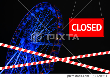 Closed due to a pandemic. Passage to ferris wheel is blocked by red and white ribbon and sign hanging is closed. Closed due to a pandemic. Passage to ferris wheel is blocked by red and white ribbon and sign hanging is closed. 65120981