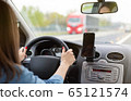 A woman driving a car on a fast road 65121574
