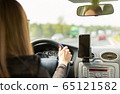 A woman driving a car on a fast road 65121582