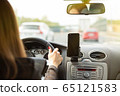 A woman driving a car on a fast road 65121583