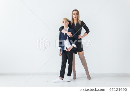 Parenting, family and single parent concept - A happy mother and teen son smiling on white background. Parenting, family and single parent concept - A happy mother and teen son smiling on white background. 65121690