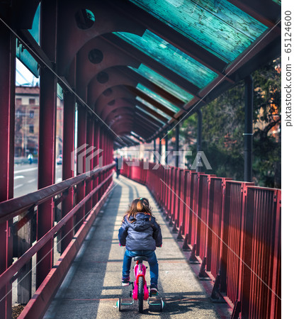 baby cycling seen from back background of red bridge deserted with no people baby cycling seen from back background of red bridge deserted with no people 65124600