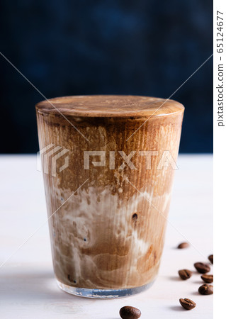 Ice coffee with milk on the white wooden table. Copy space. 65124677