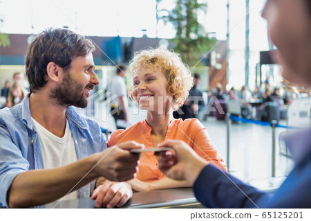 Portrait of man giving passport to passenger 65125201