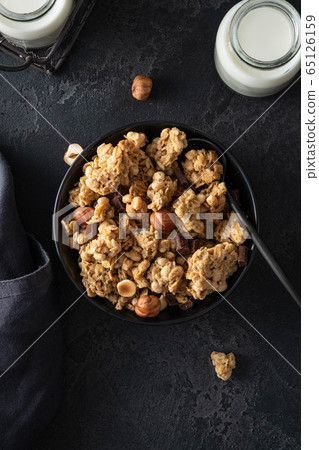 Chocolate muesli on dark background. Flat lay, top view, close up. Chocolate muesli on dark background. Flat lay, top view, close up. 65126159