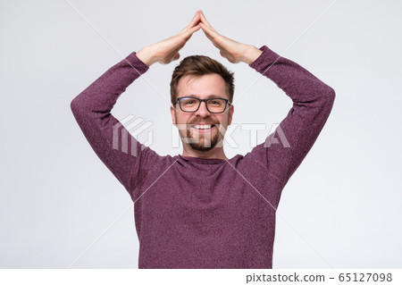 man in glasses with beard holding two hands above man in glasses with beard holding two hands above 65127098