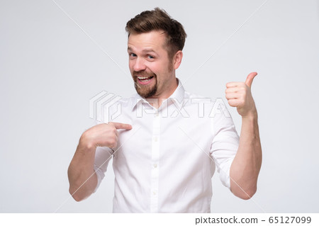 man shows himself with thumbs, smiles satisfied 65127099