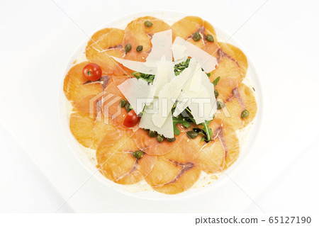 Salmon sliced carpaccio with arugula and sauce closeup shot in a restaurant. Salmon sliced carpaccio with arugula and sauce closeup shot in a restaurant. 65127190