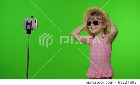 Girl child makes selfie vlog, blogging, video call on mobile phone. Vacation sea Girl child makes selfie vlog, blogging, video call on mobile phone. Vacation sea 65127692
