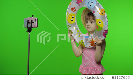 Girl child makes selfie vlog, blogging, video call on mobile phone. Vacation sea 65127693
