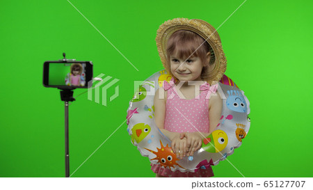 Girl child makes selfie vlog, blogging, video call on mobile phone. Vacation sea 65127707