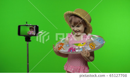 Girl child makes selfie vlog, blogging, video call on mobile phone. Vacation sea 65127708